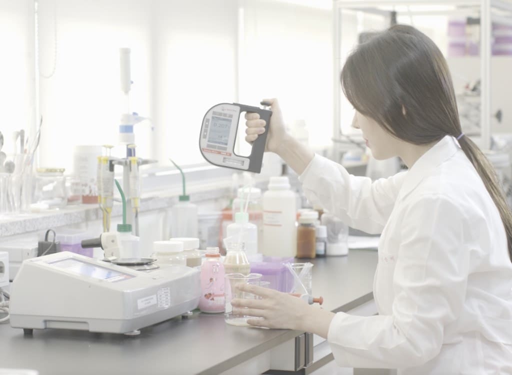 품질 검사 실험실에서 밀도계로 측정하는 연구원